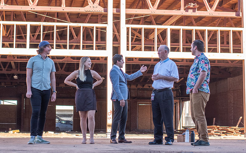 Prof. Max Hulburt, Eleazar Palma, President Derry Connolly, Prof. Katelyn Slater, and Prof. Joe Connolly visit the construction site to see the latest work.