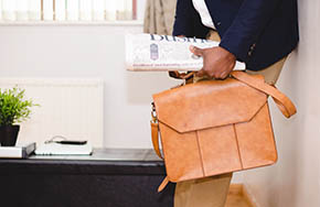 Man Holding Bag and Newspaper