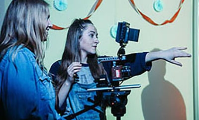 Two Girls Directing and Holding Camera